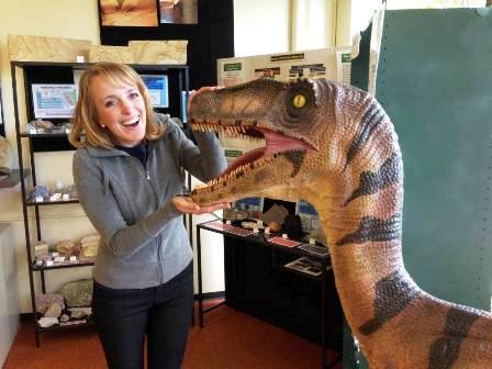Marianne Pike, miembro del personal de Alianza Científica de la Creación, amistosa con un dinosaurio amigo en el Northwest Treasures Museum en Seattle, Washington